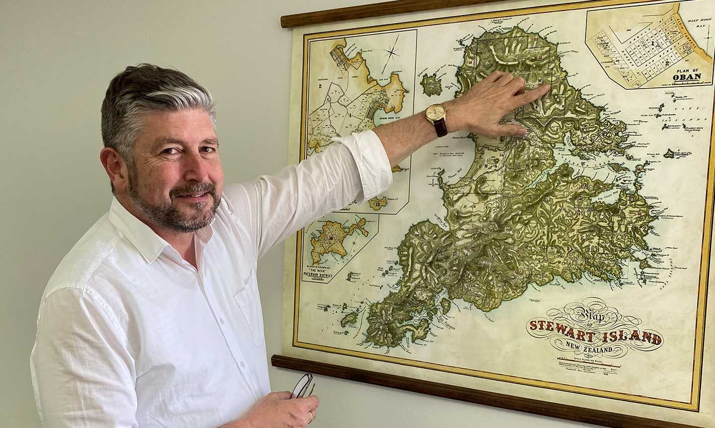 picture of Alan Groves pointing out a Rakiura study site on a map of Stewart Island.
